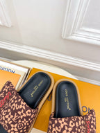 Brown monogram slide sandals close-up with dark navy footbed and thick sole
