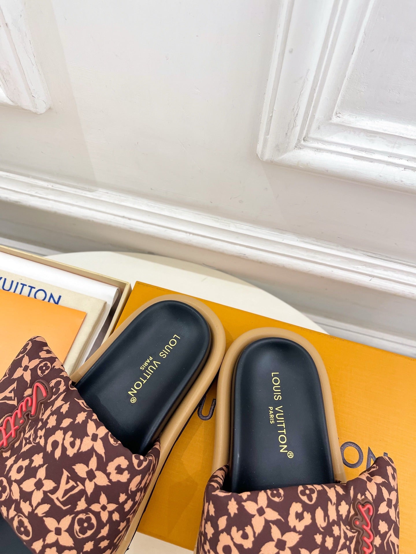 Brown monogram slide sandals close-up with dark navy footbed and thick sole