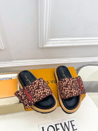 Brown patterned slide sandals with dark navy footbed and wide fabric strap