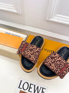 Brown patterned slide sandals with dark navy soles and cushioned footbed