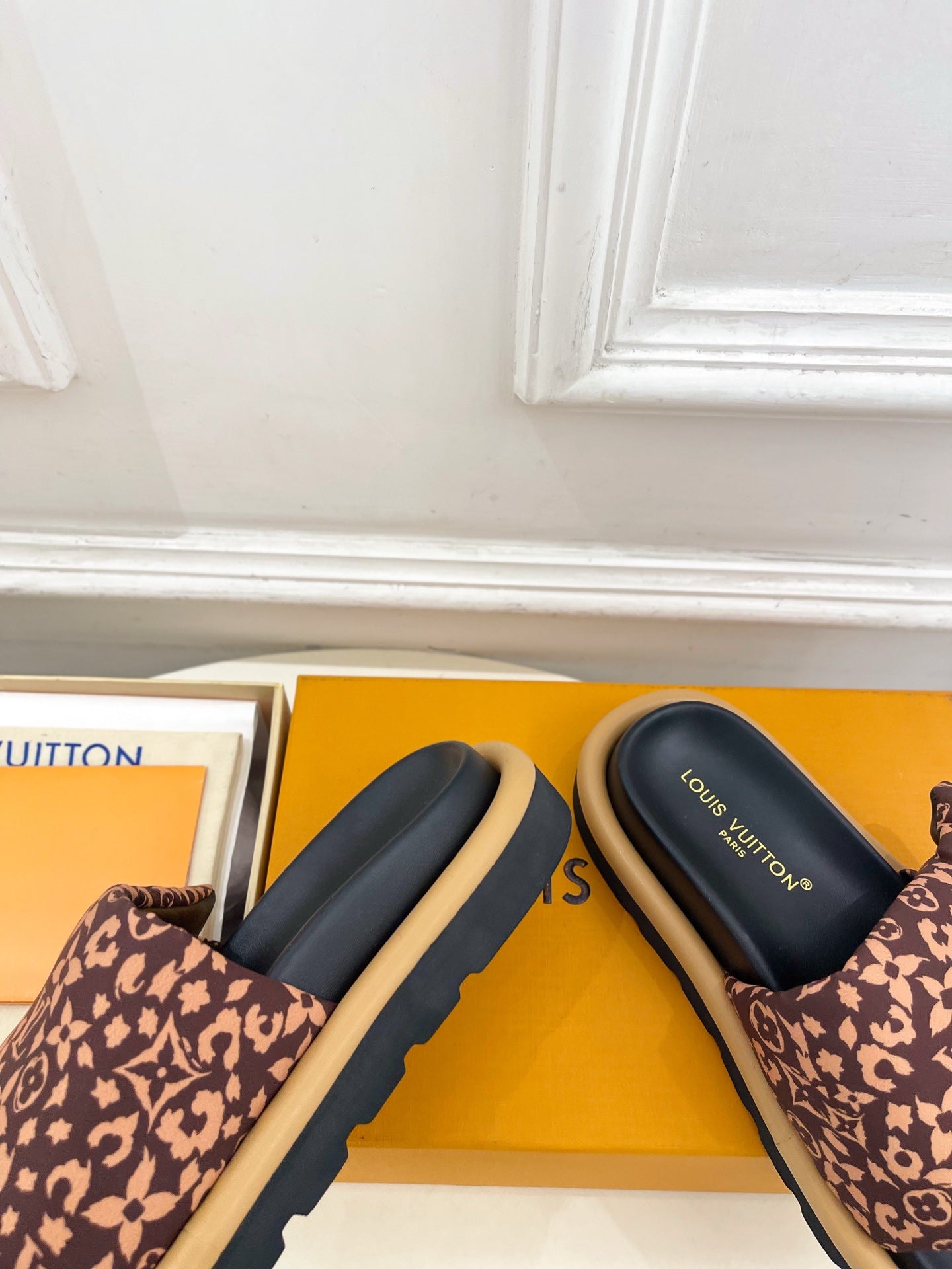 Brown monogram slide sandals with dark navy footbeds and chunky rubber sole
