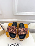 Brown monogram slide sandals with dark navy footbed and wide fabric band
