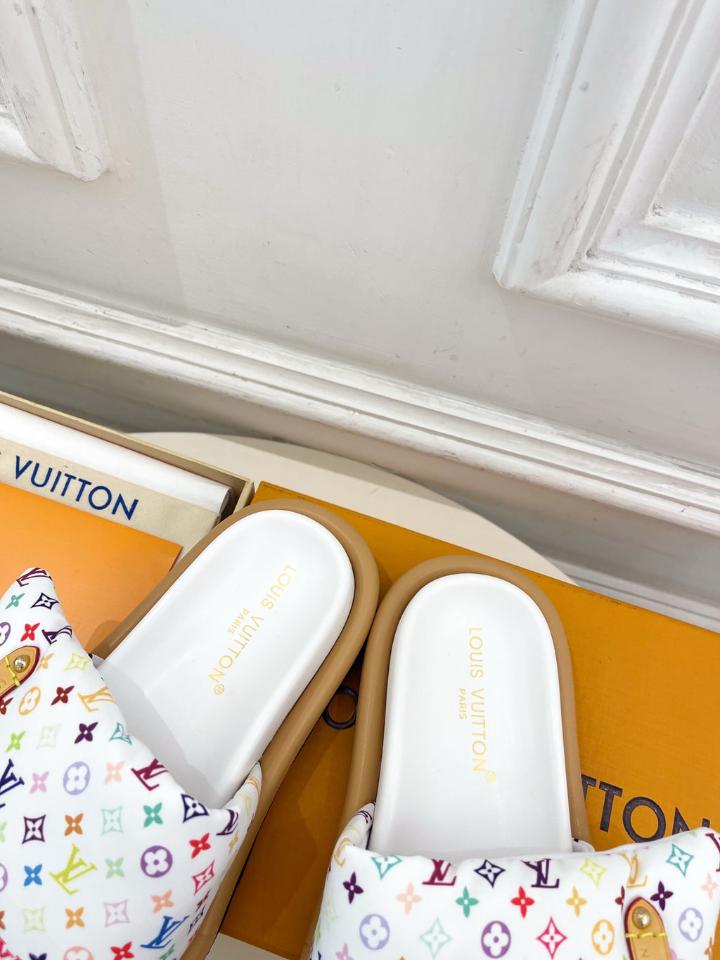 Logo slide sandals with white footbed and multicolor monogram straps, side view