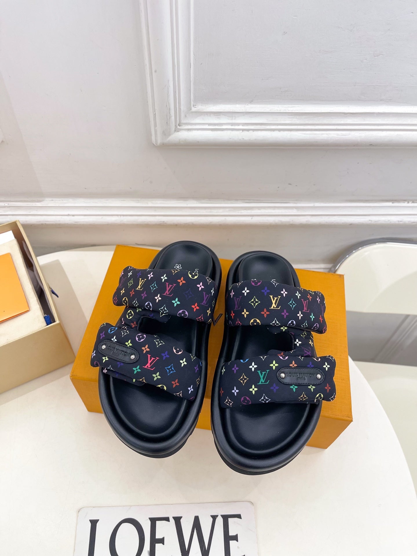 Luxury slide sandals with dark navy straps and multicolor monogram logo print