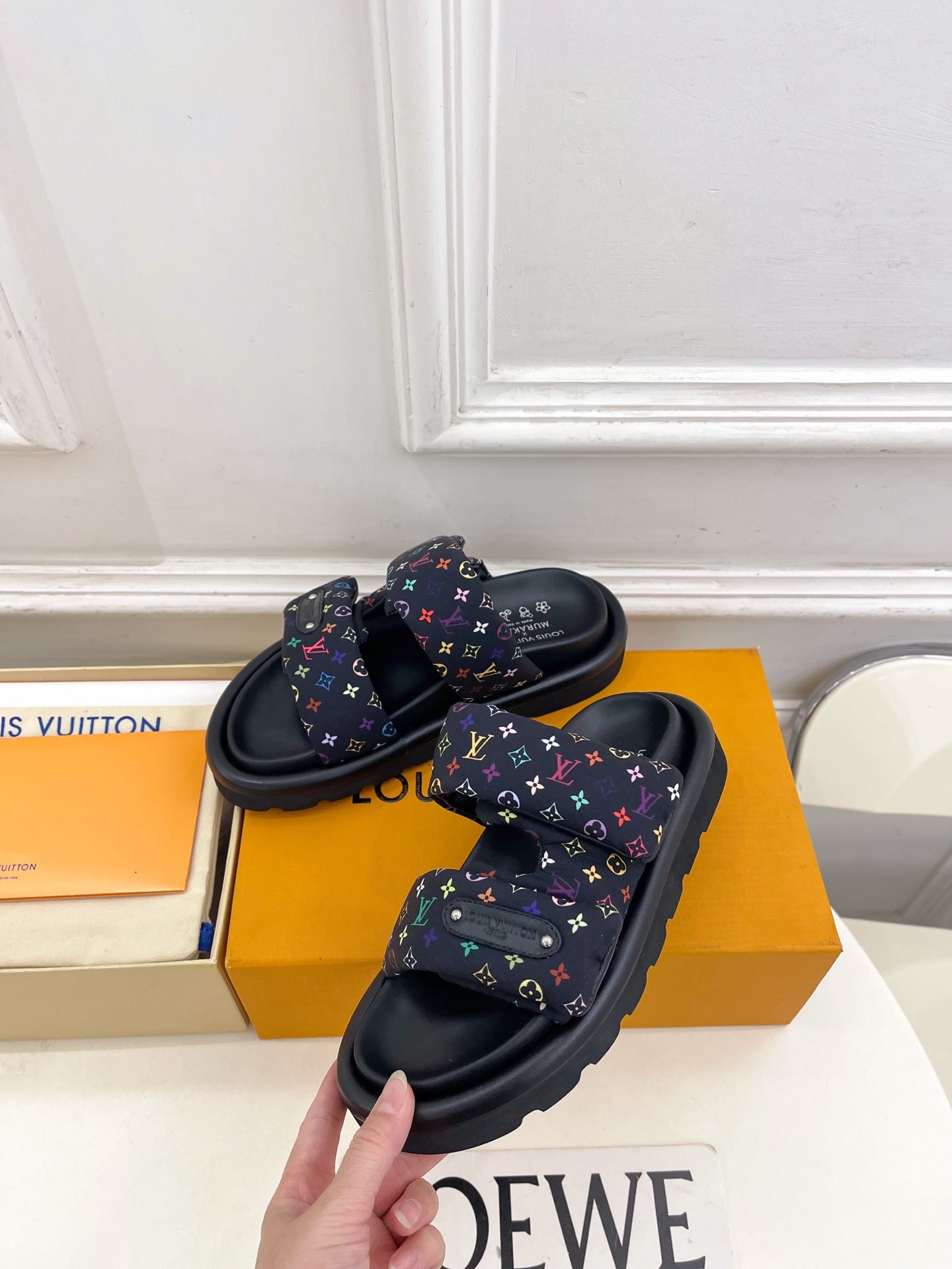 Luxury slide sandals with dark navy straps and multicolor monogram print, side angle