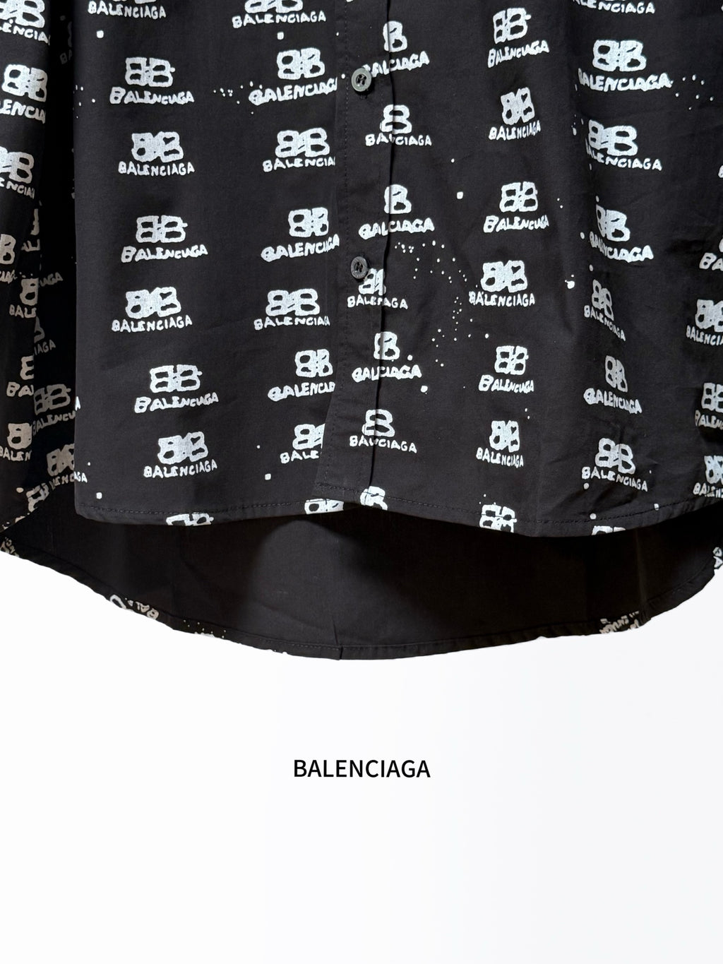 Black long-sleeve shirt hem with Balenciaga logo repeat and solid underside.