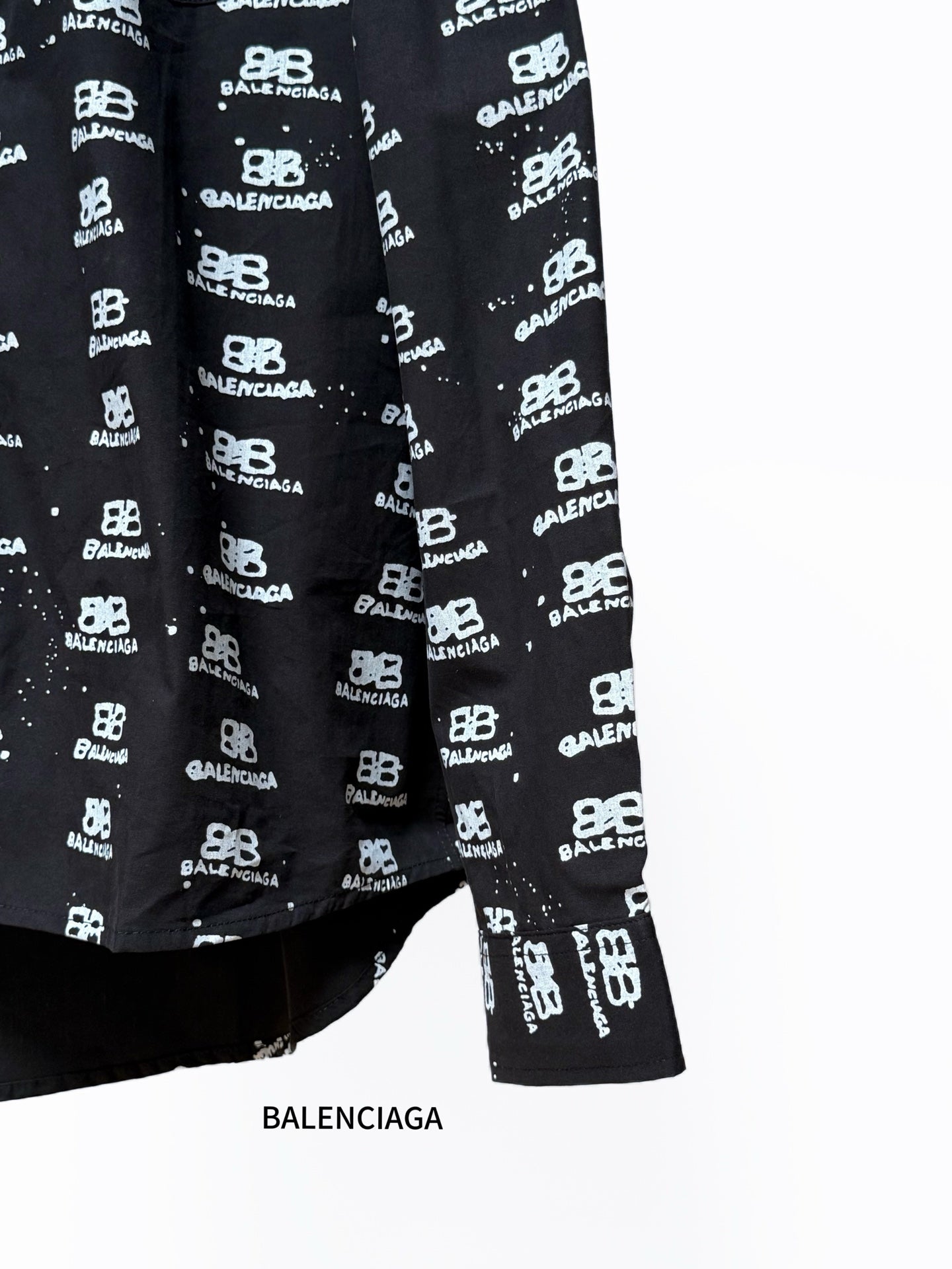 Black long-sleeve shirt with Balenciaga logo repeat, lower front and hem.