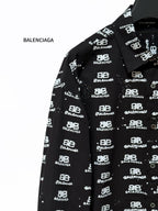 Black long-sleeve shirt close-up of spread collar with Balenciaga logo pattern.