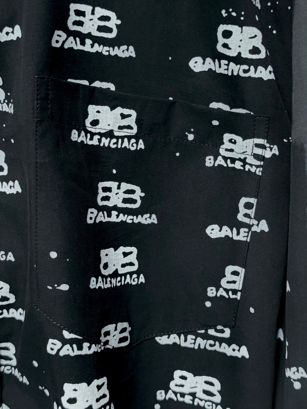 Black front pocket on shirt with Balenciaga logo repeat, close-up.