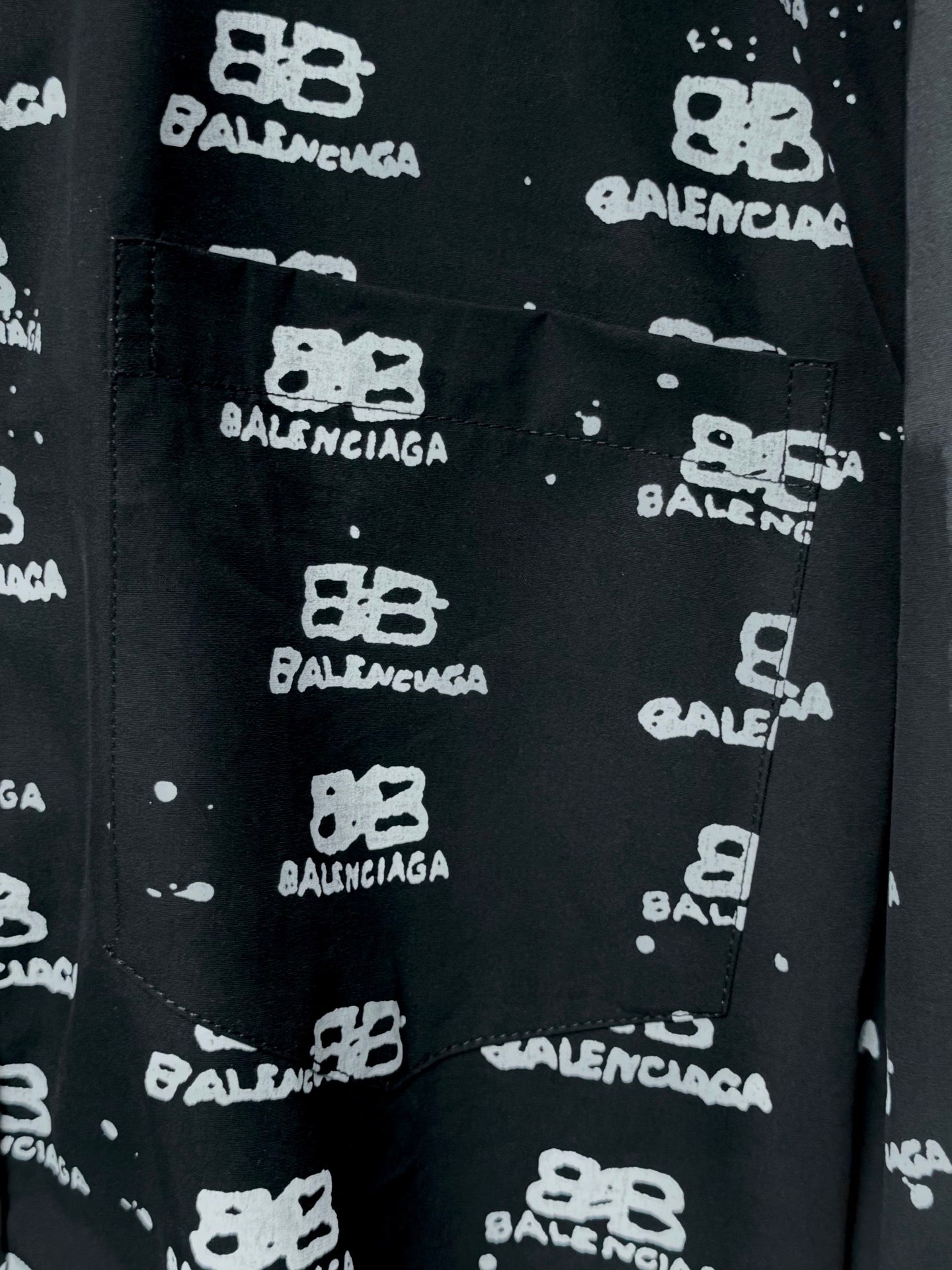 Black front pocket on shirt with Balenciaga logo repeat, close-up.