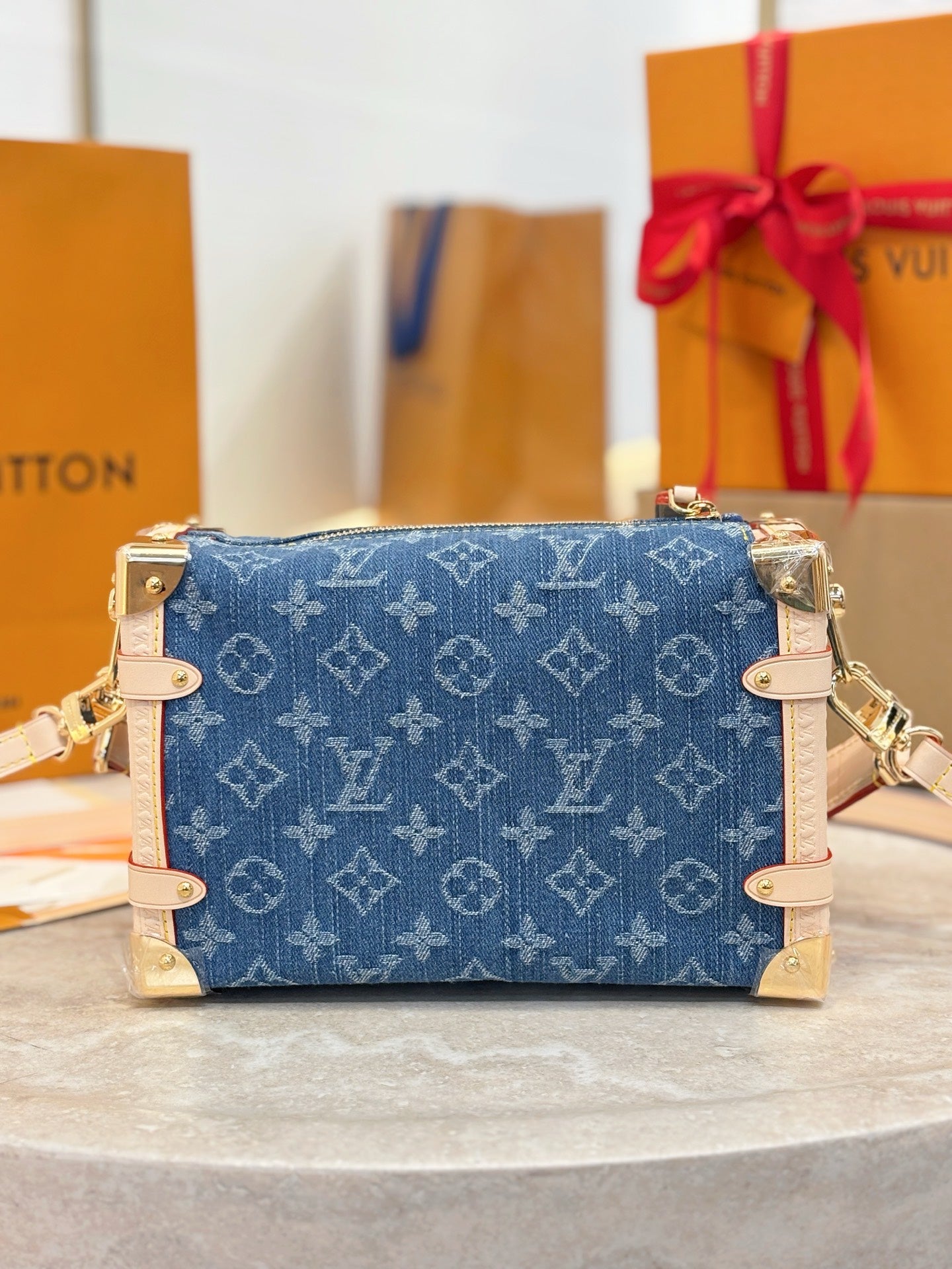 Louis Vuitton bag blue monogram canvas, white strap handles, gold clasp, straight view
