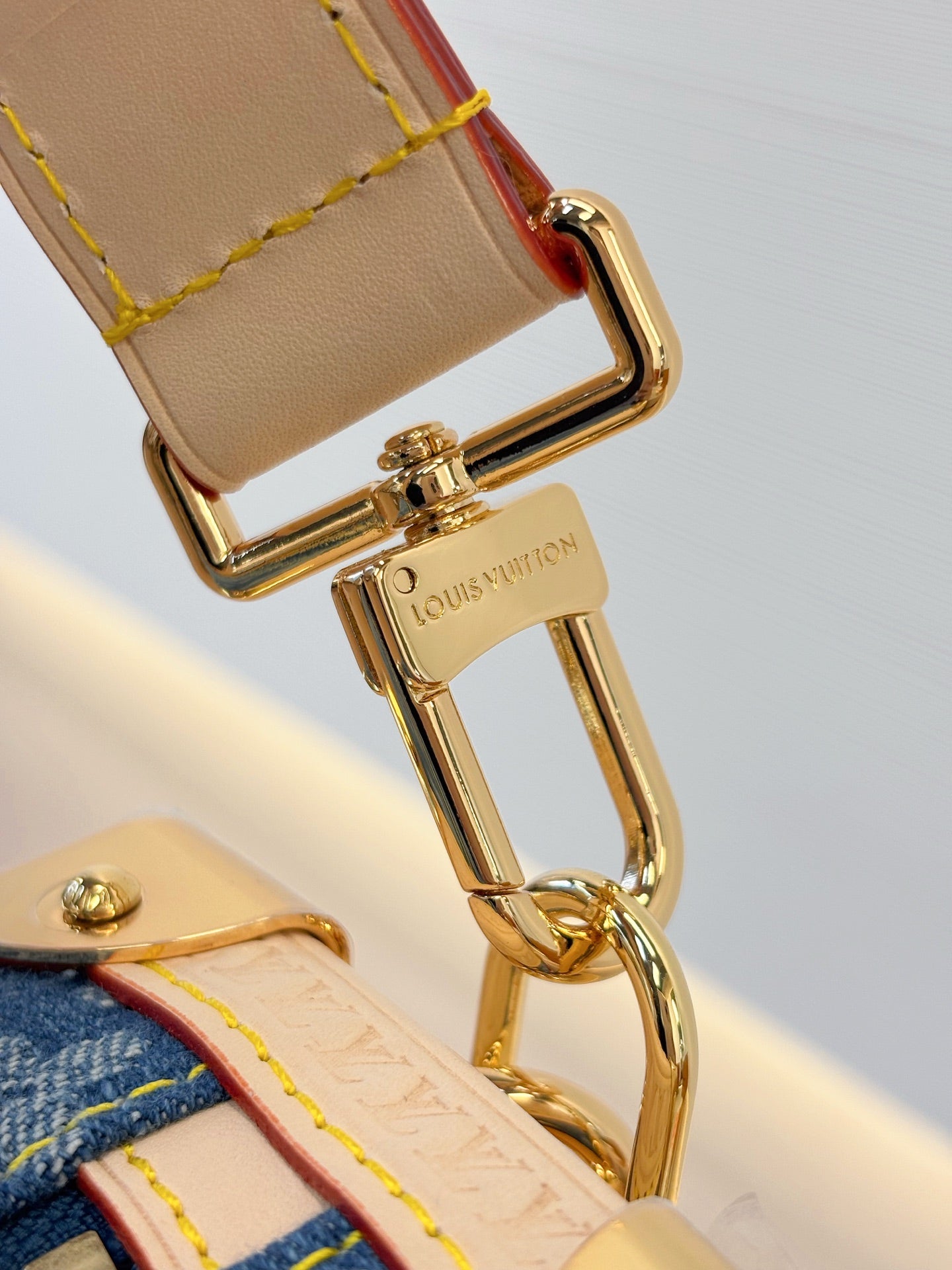 Louis Vuitton bag close-up of gold key ring hardware and blue monogram canvas