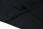 Black T-shirt hem with side seam and stitched detail close-up