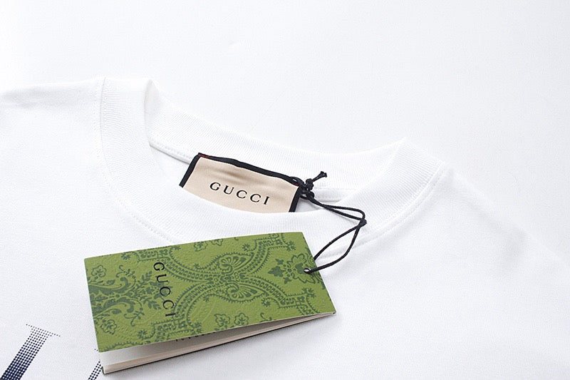 White Gucci T-shirt with attached green and beige hang tag