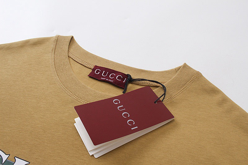 Tan crew-neck T-shirt with Gucci label and hang tag at collar
