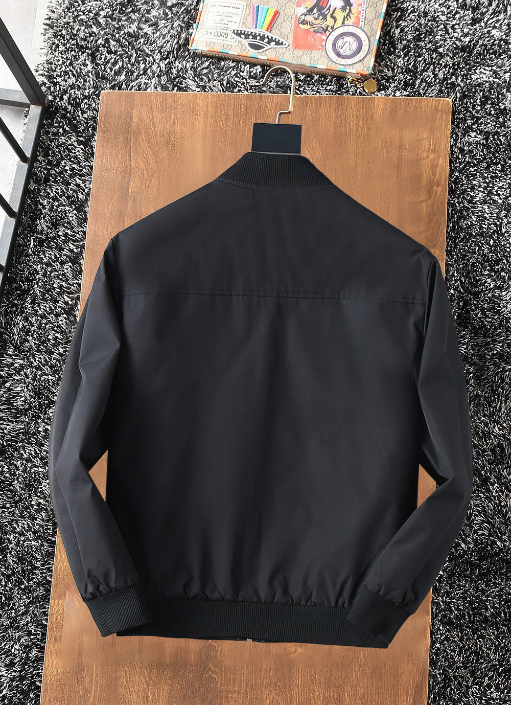 Black zip-up jacket back view with stand collar