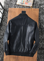 Black zip-up jacket back view with stand collar and ribbed hem