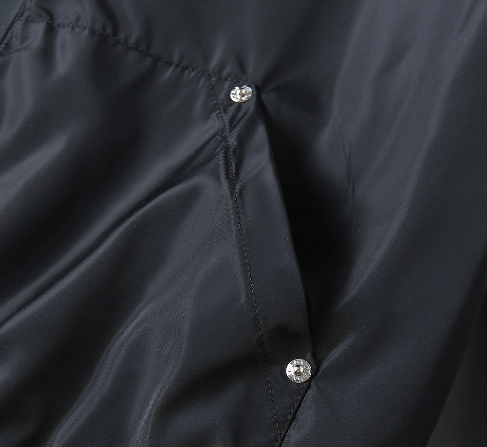 Prada black jacket fabric close-up with snap buttons on front panel