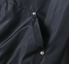 Prada black jacket fabric close-up with snap buttons on front panel