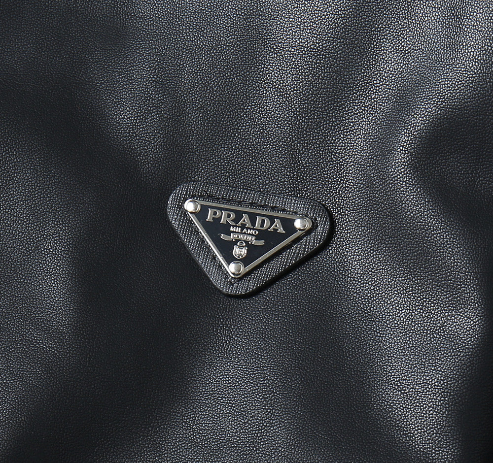 Prada logo patch on dark leather jacket front triangle emblem