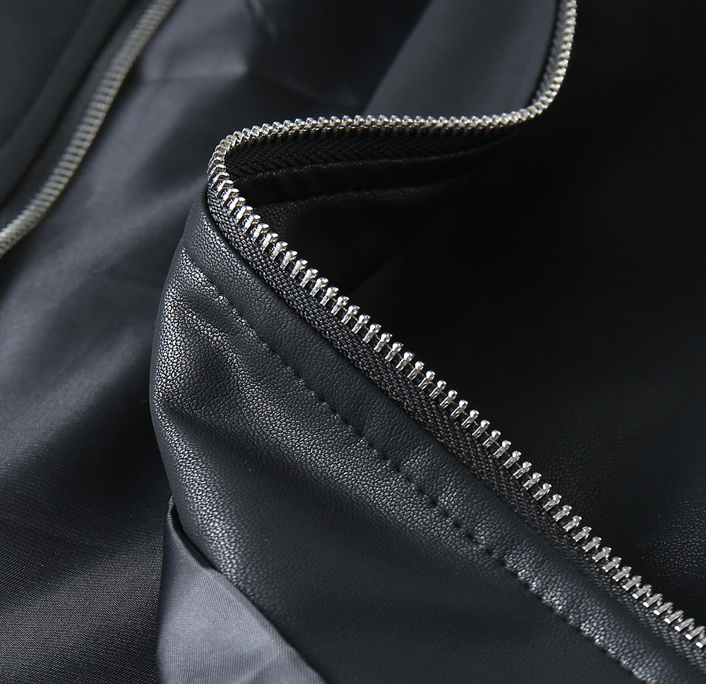 Black leather jacket sleeve detail with silver zipper track and stitching