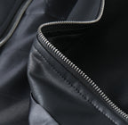 Black leather jacket sleeve detail with silver zipper track and stitching