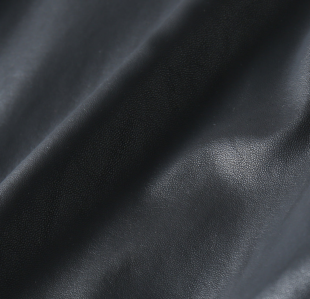 Black leather jacket fabric close-up with fine grain texture