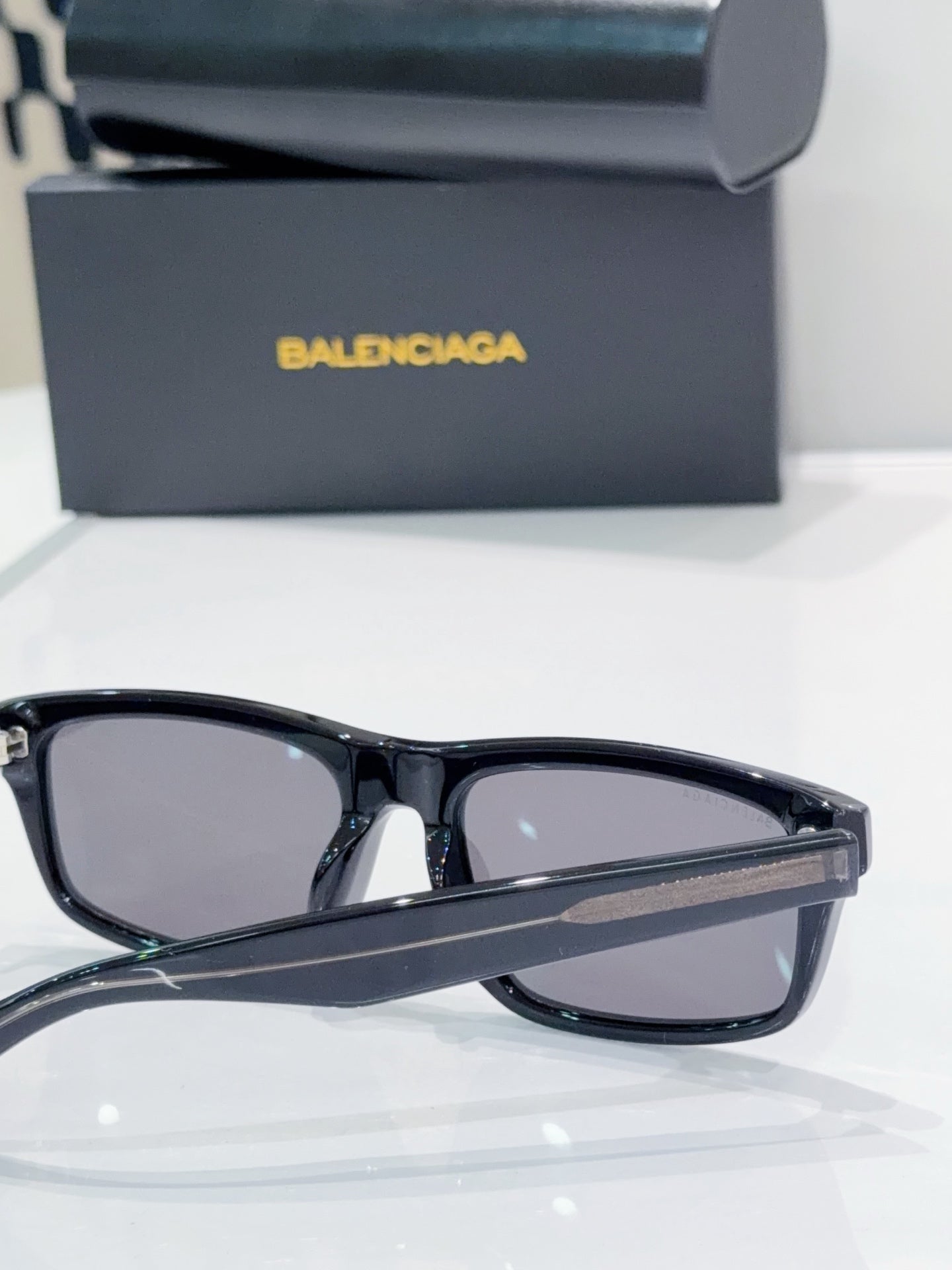 Sunglasses with black frame and dark lenses, front close-up