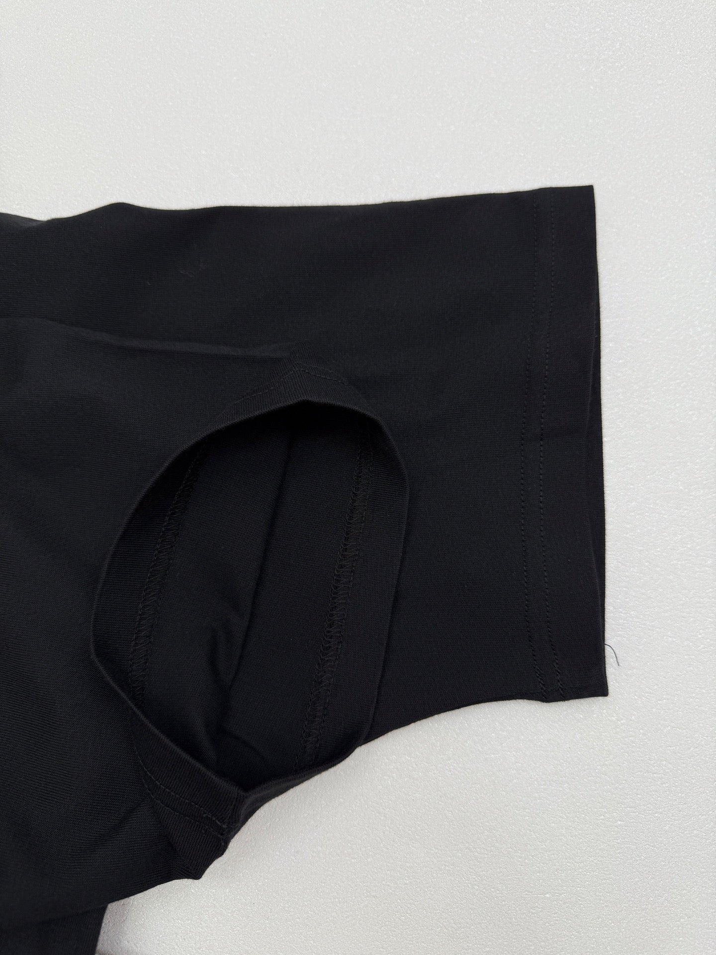 Black short-sleeve T-shirt with side curved hem and stitched seams