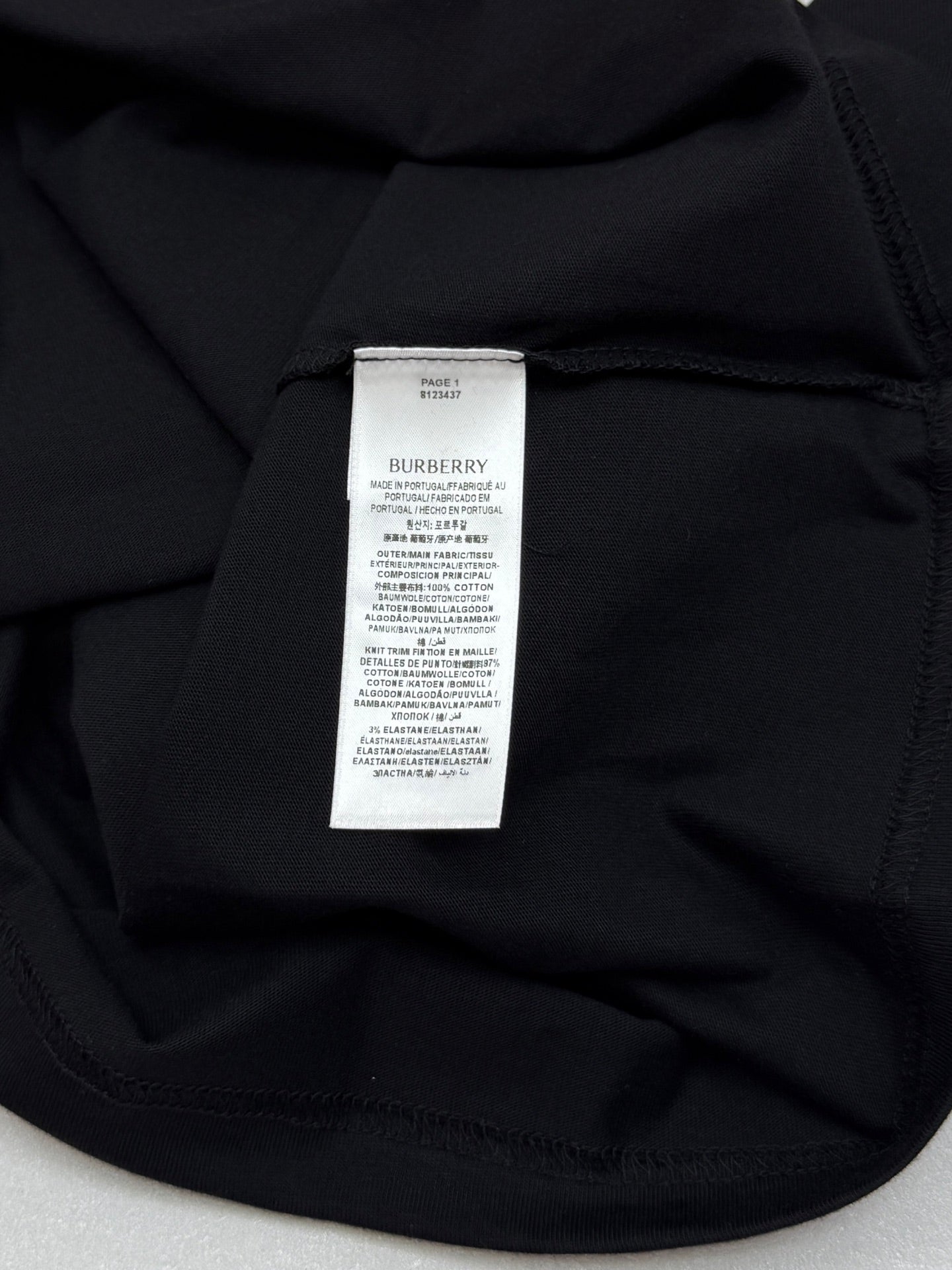 Black crewneck T-shirt with white label at inner neckline