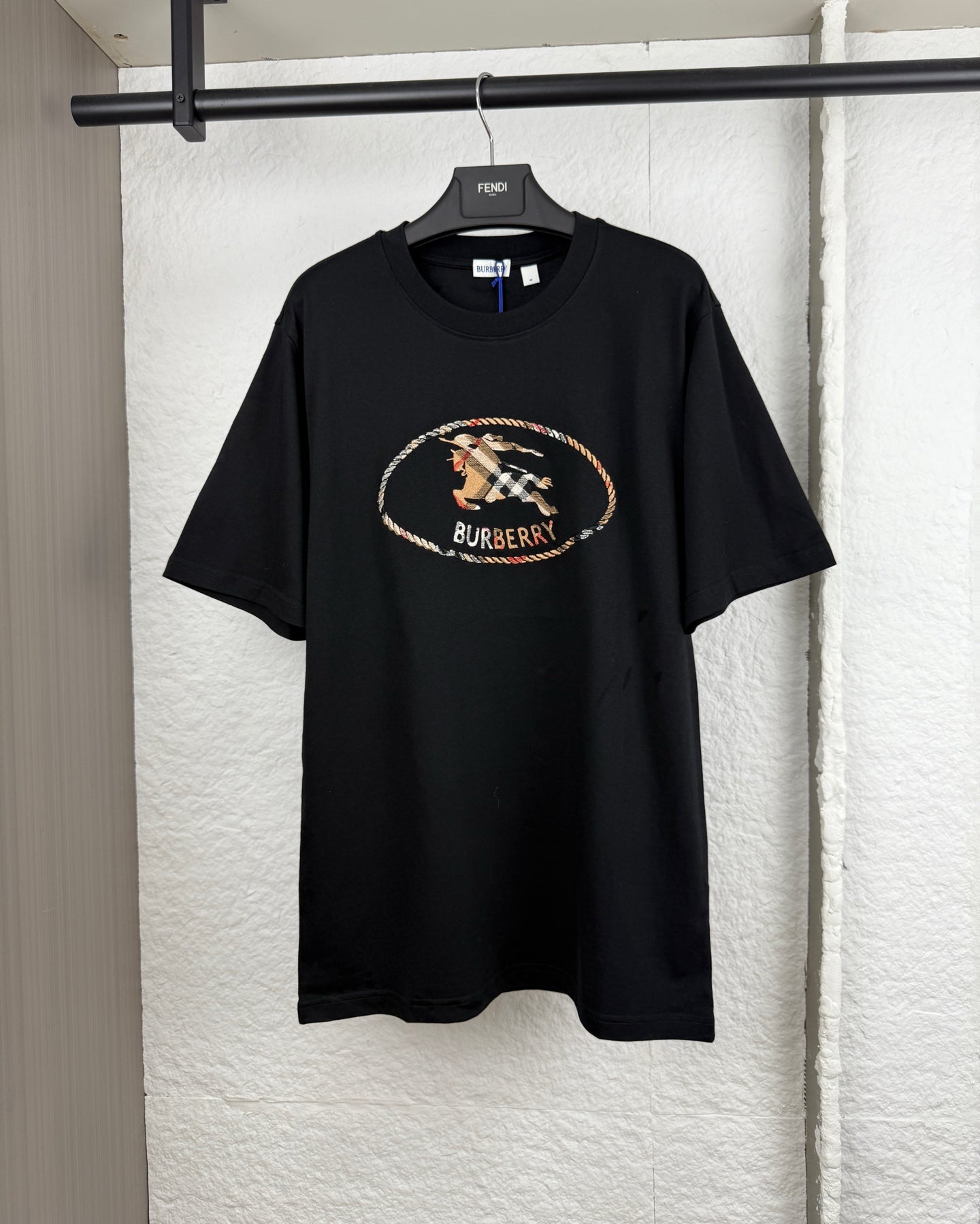 Black short-sleeve crewneck T-shirt with oval logo graphic at chest