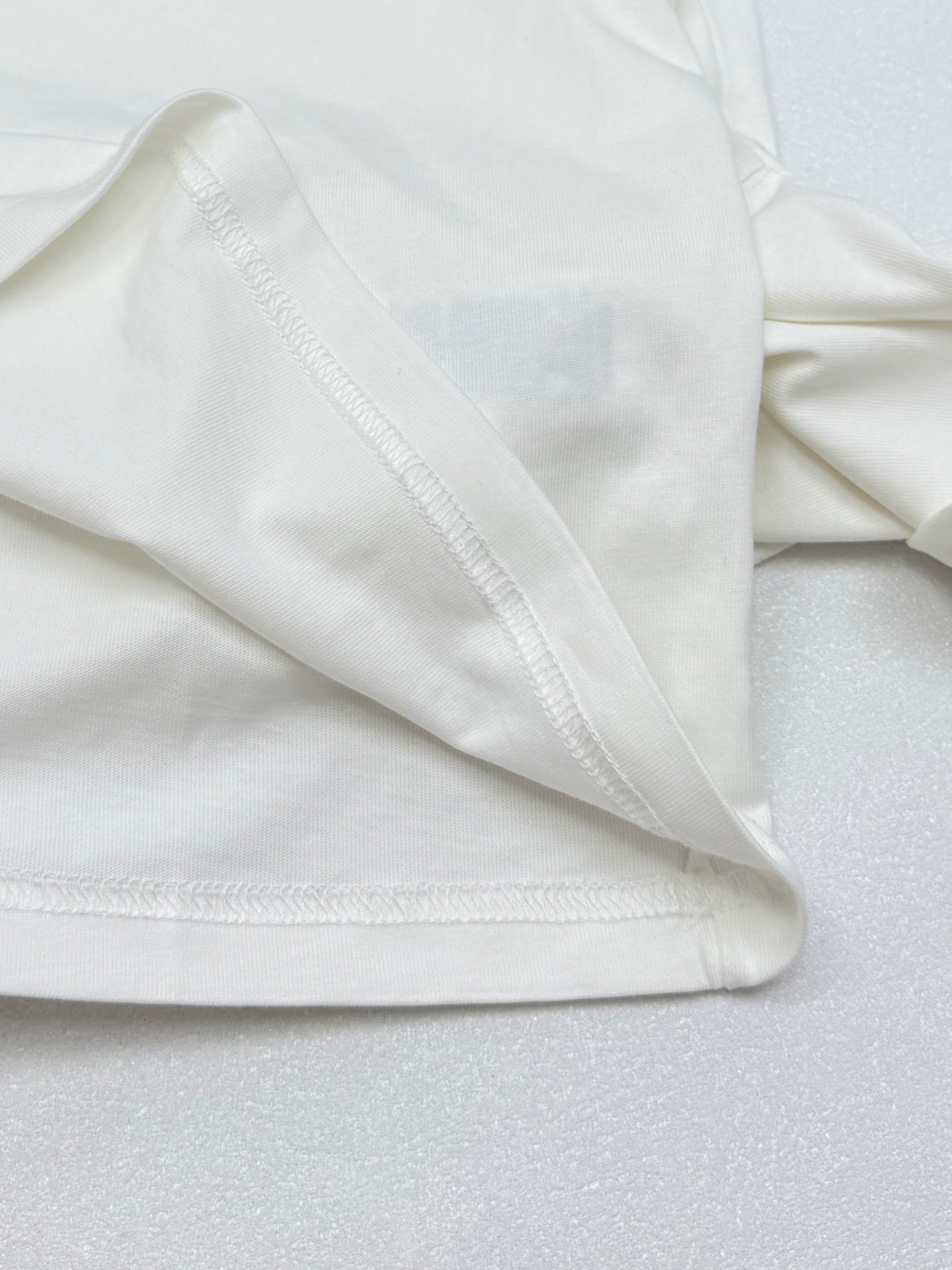 White T-shirt sleeve hem with double-stitched edge.