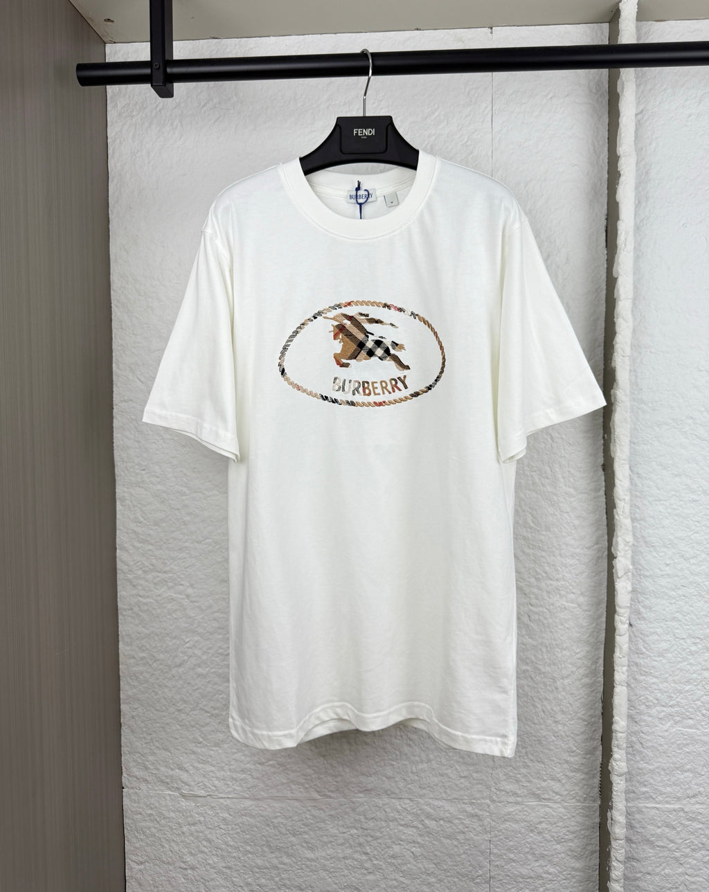 White short-sleeve T-shirt with Burberry logo patch on the chest.