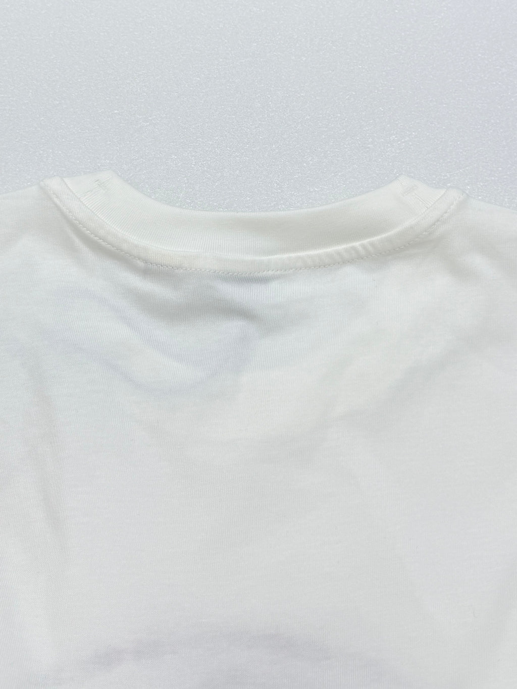 White short-sleeve T-shirt back neckline and shoulder seam.