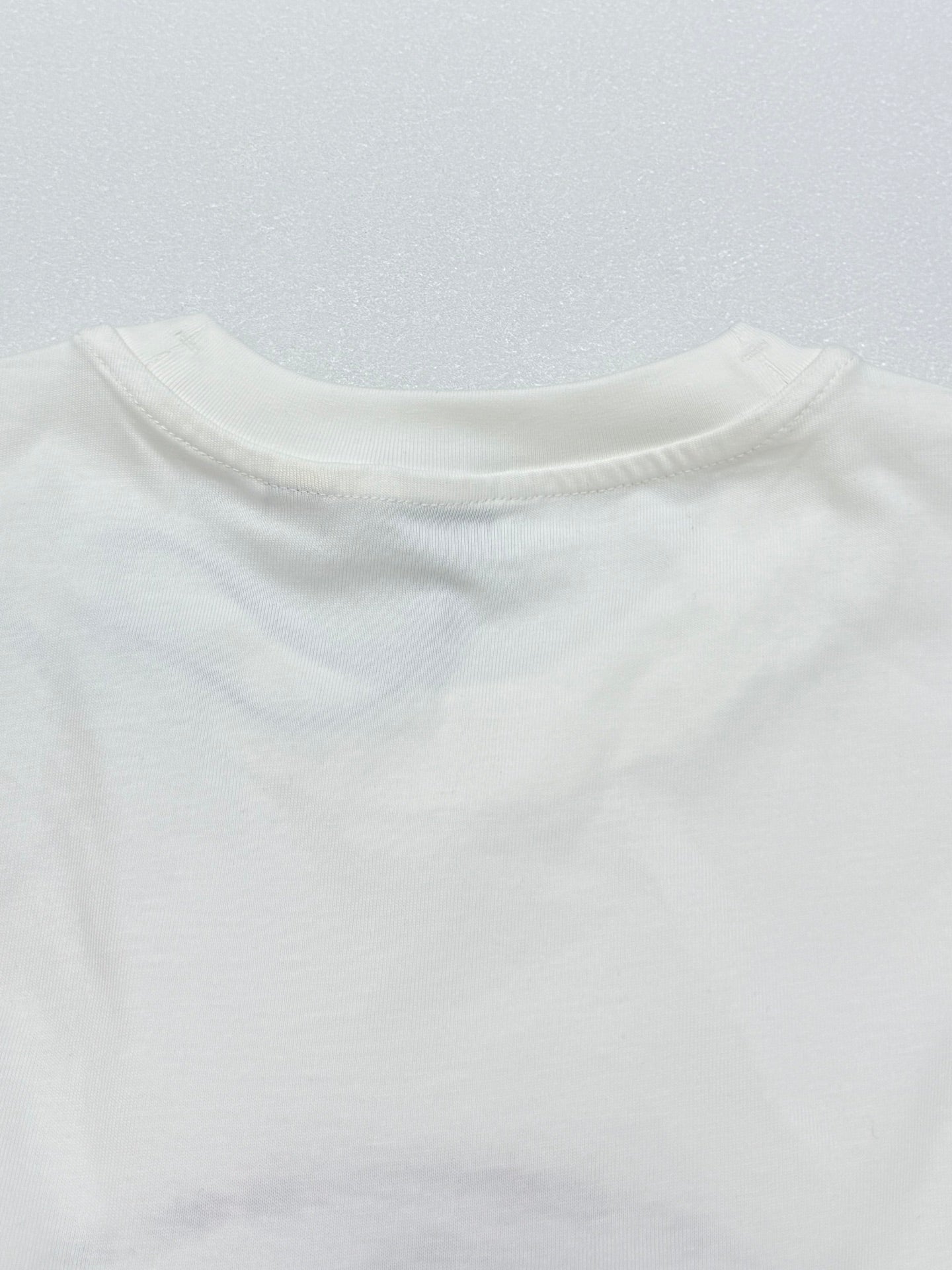 White short-sleeve T-shirt back neckline and shoulder seam.