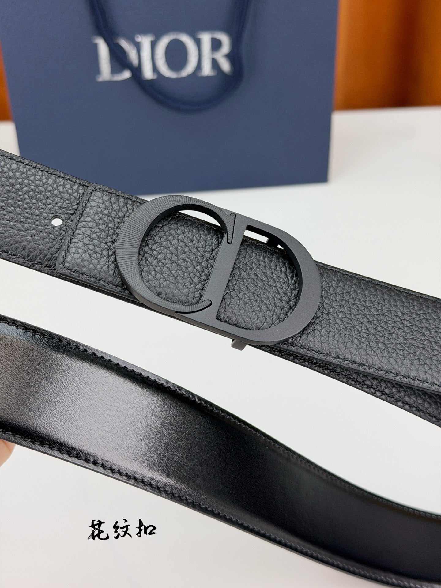 Dior belt buckle detail with dark gray pebble-grain leather keeper