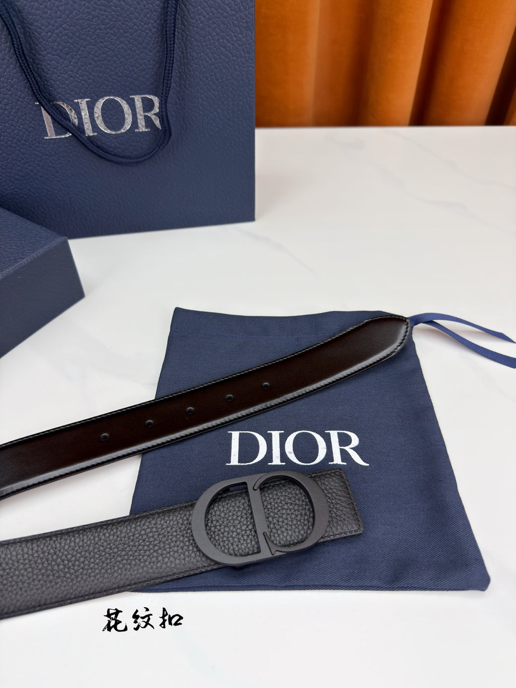 Dior belt with dark gray leather strap, circular buckle, and keeper loop