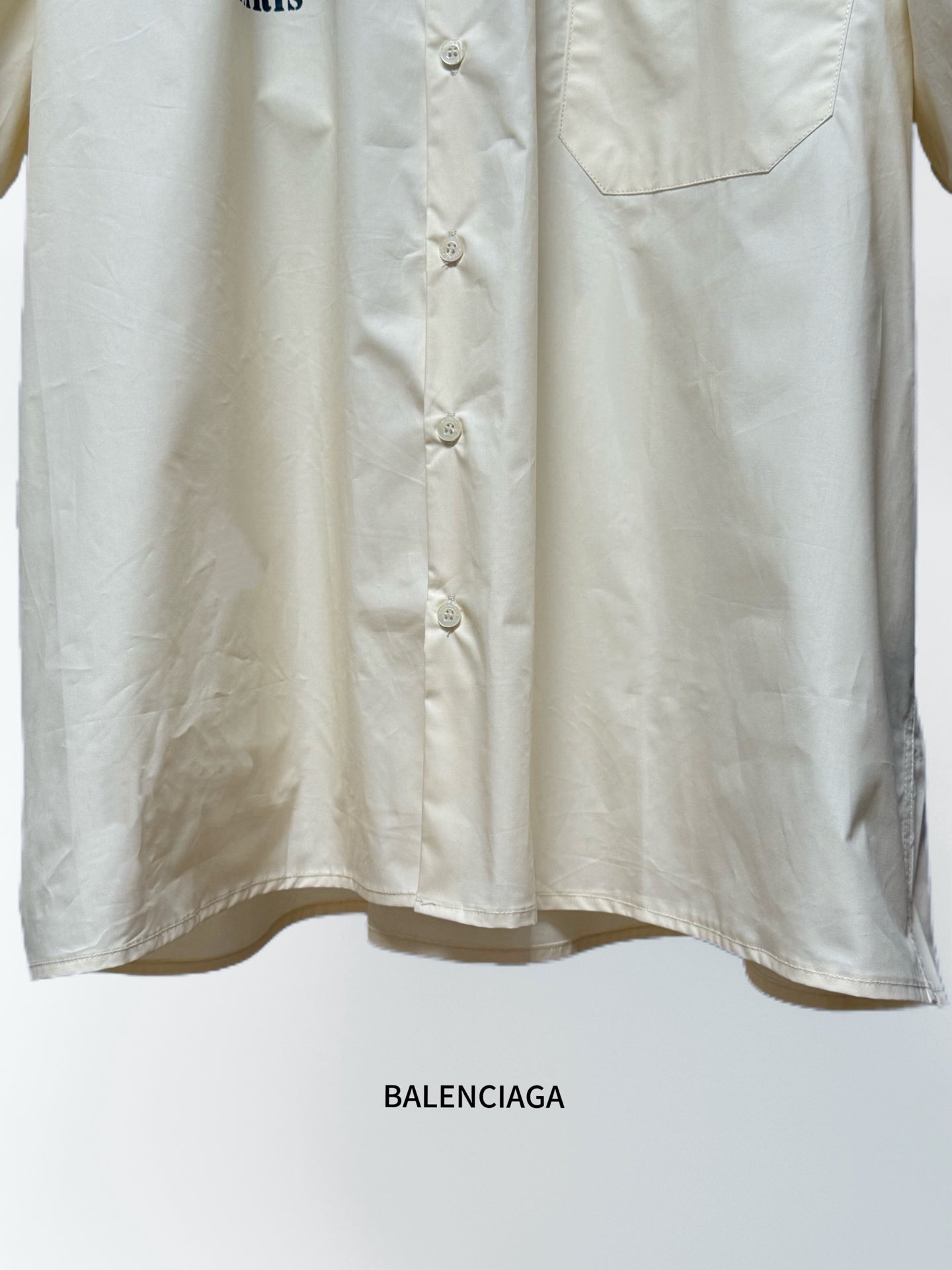 Cream short-sleeve button-up shirt with front button placket and chest pocket