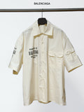Cream short-sleeve button-up shirt with pointed collar and front button placket