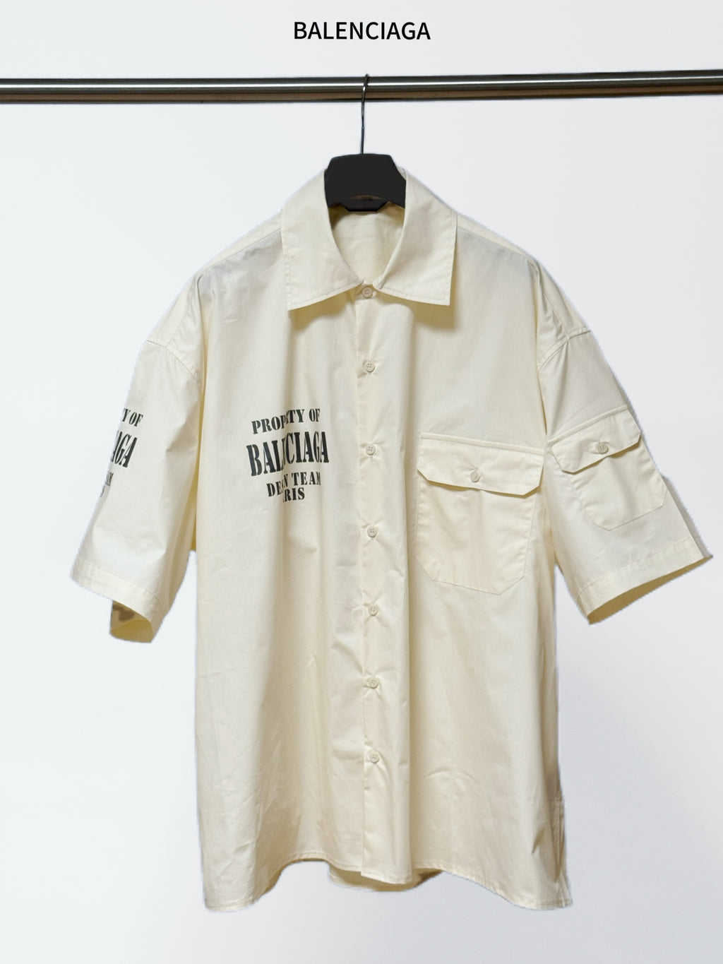 Balenciaga cream short-sleeve button shirt with pointed collar and chest pockets, logo print.