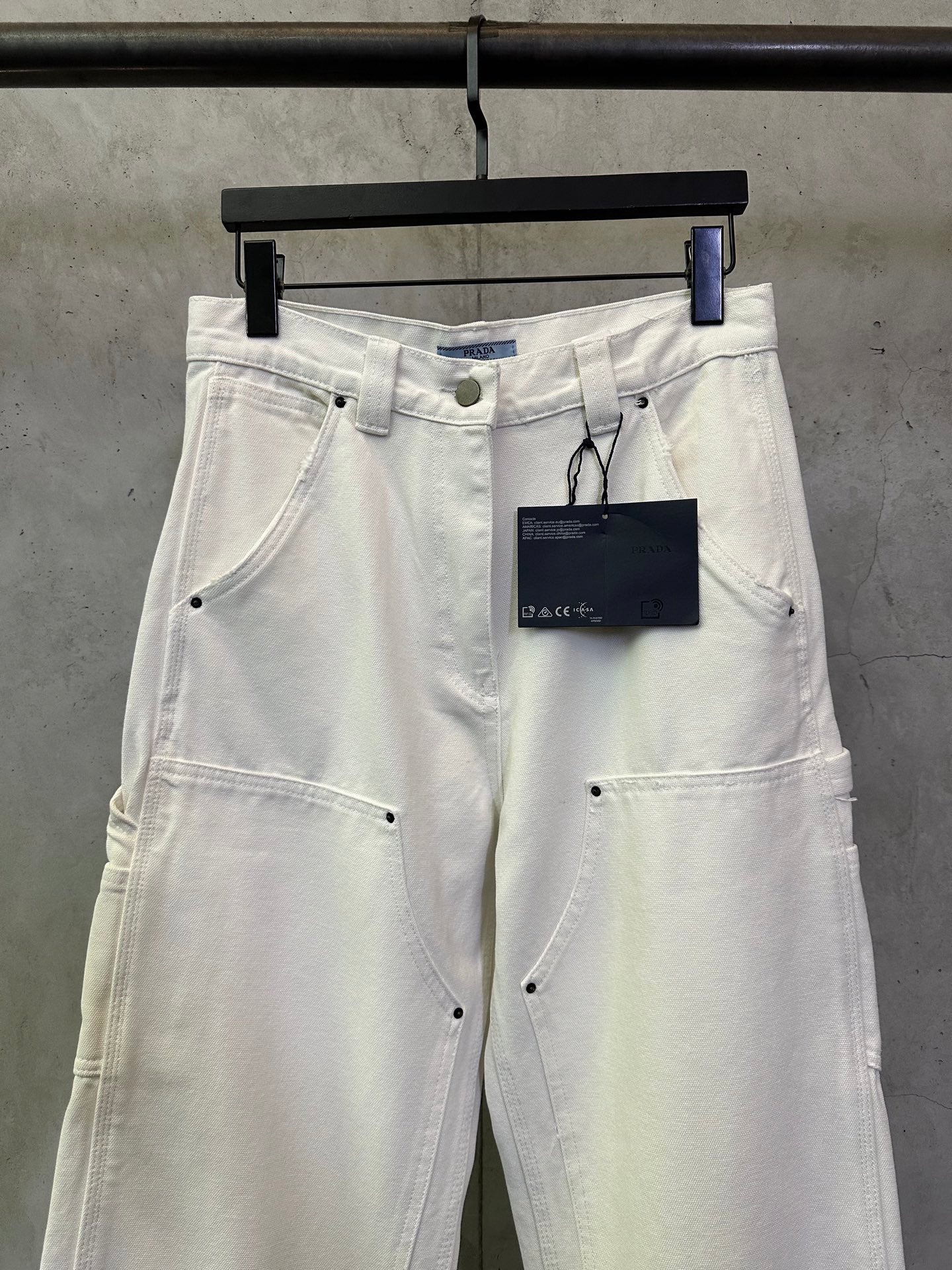 Prada white cargo pants front view with hanging brand tag