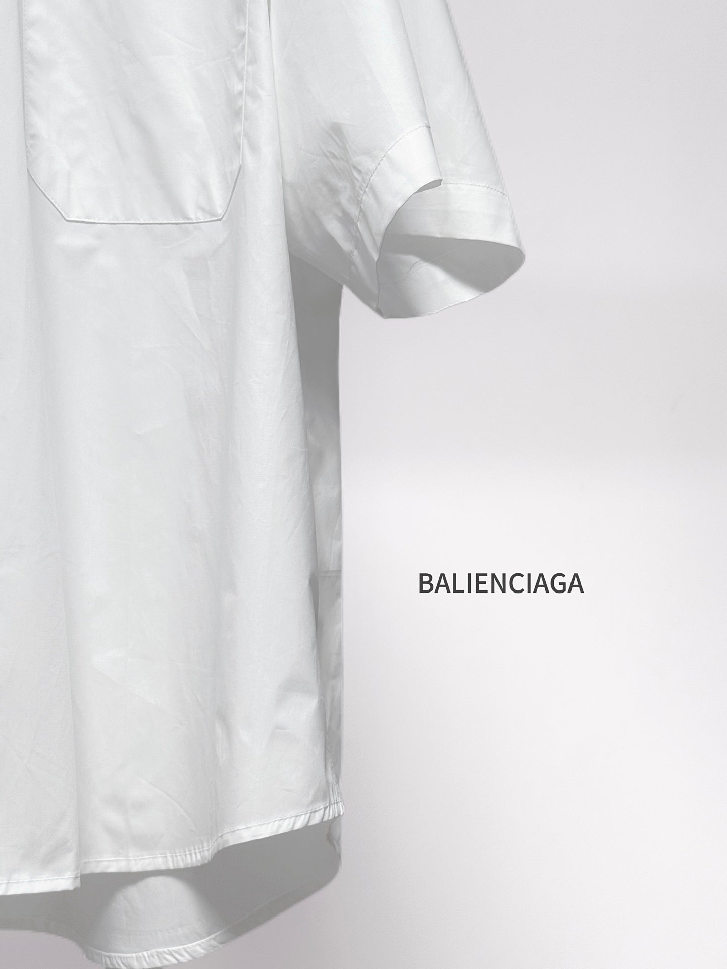 Balenciaga white short-sleeve button shirt sleeve and curved hem detail