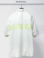 Balenciaga white short-sleeve shirt, back view with neon logo-style print and tag