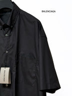 Men's short-sleeve button-up shirt, black, angled view with chest pocket detail
