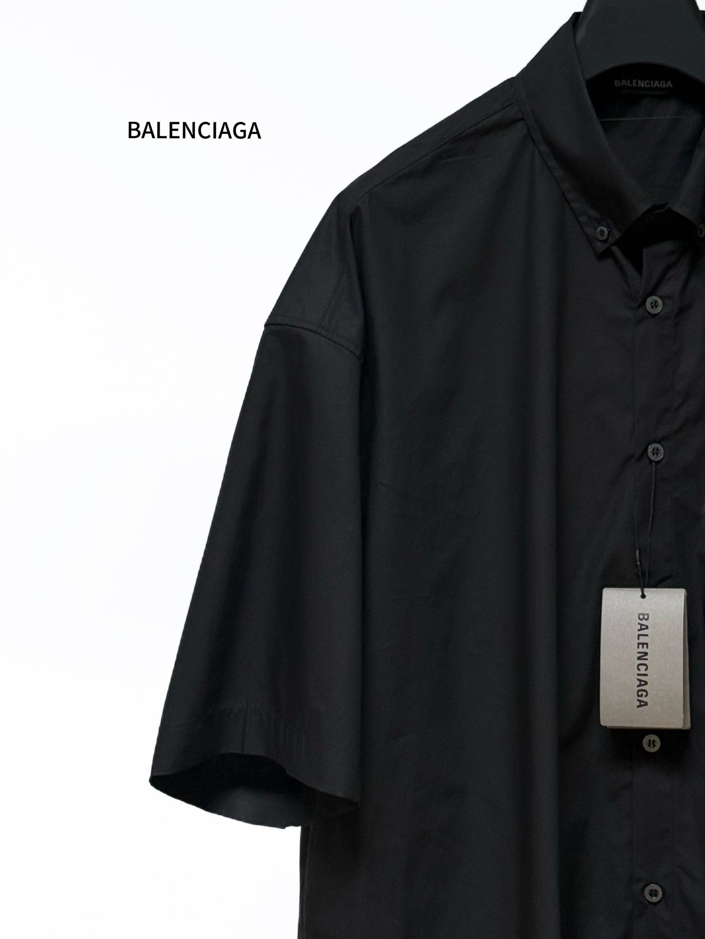 Men's short-sleeve button-up shirt, black, side view with button placket and chest pocket