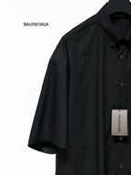 Black short-sleeve shirt with button placket and point collar, side view