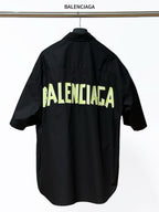 Men's short-sleeve button-up shirt, black, with neon BALENCIAGA logo print on back