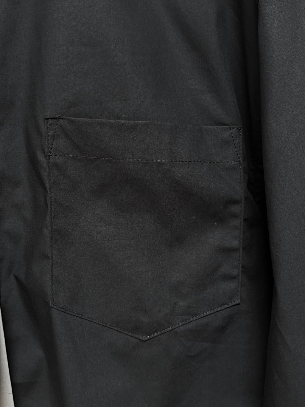 Men's short-sleeve button-up shirt, black, close-up of chest pocket