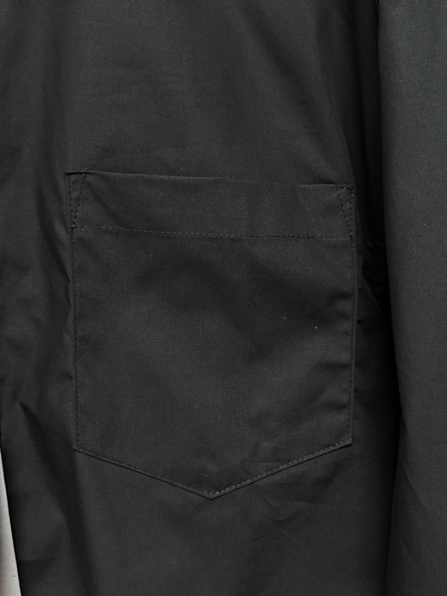 Men's short-sleeve button-up shirt, black, close-up of chest pocket