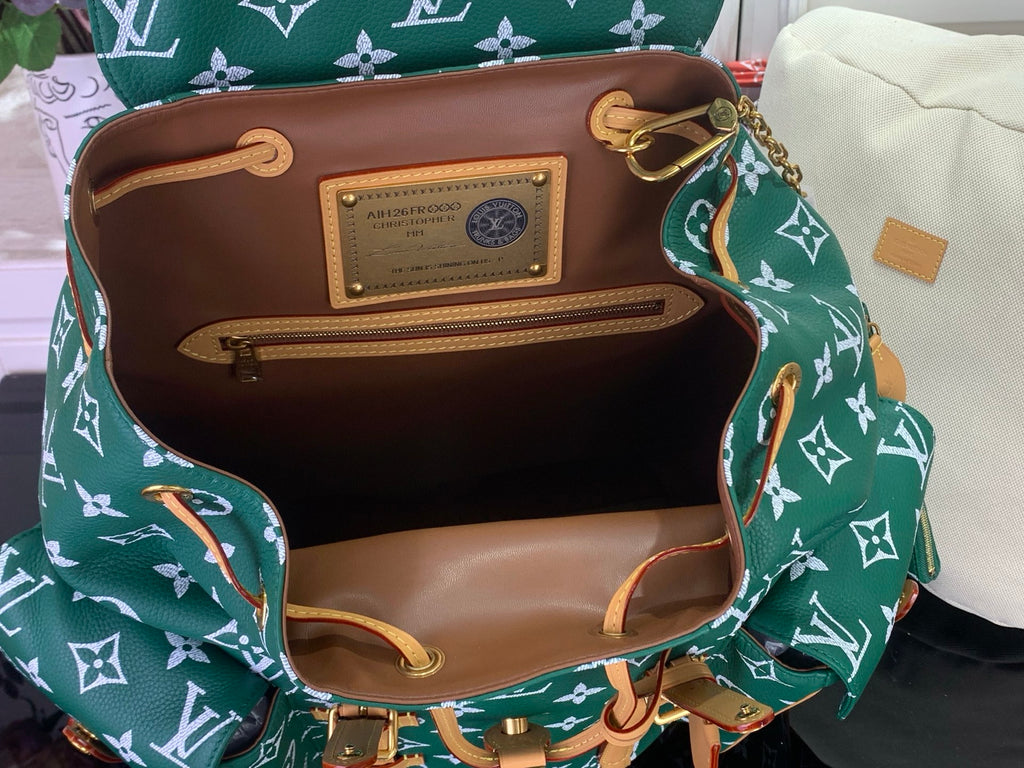 Louis Vuitton patterned handbag open-top view with brown lining and inside pocket label